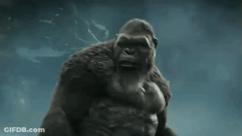 A Giant Gorilla Is Standing In The Water With His Arms Outstretched . GIF