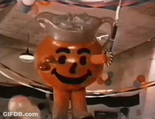 A Giant Inflatable Orange Man With A Pitcher Of Iced Tea On His Head . GIF
