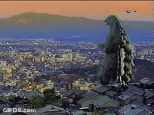 A Giant Monster Is Standing On Top Of A Rooftop Overlooking A City GIF
