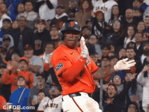A Giants Baseball Player Stands In Front Of A Crowd Holding His Bat GIF