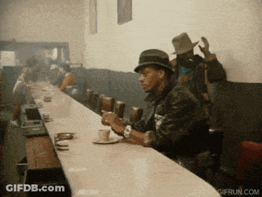 A Gif From Gifrun.com Shows A Man Sitting At A Counter GIF