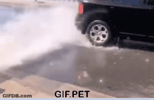 A Gif Of A Car Driving Through A Puddle With Gif.pet Written Below It GIF