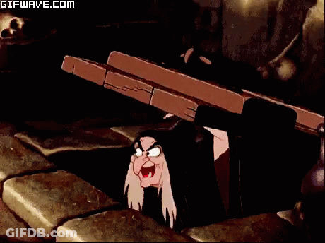 A Gifwave.com Animated Image Of A Witch Peeking Out From Under A Table GIF