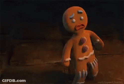 A Gingerbread Man From Shrek Is Standing On A Wooden Floor . GIF