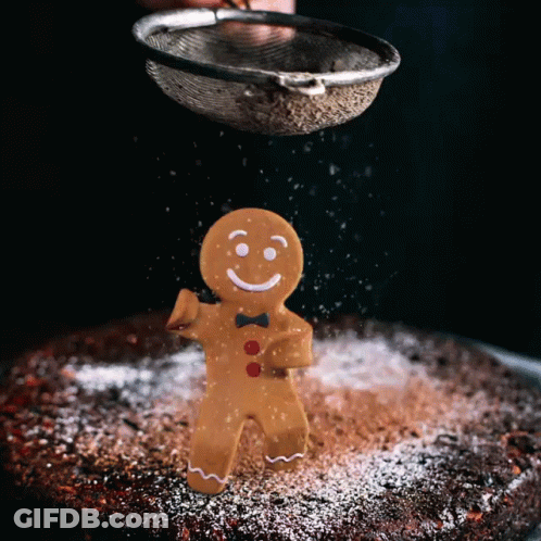A Gingerbread Man Is Being Sprinkled With Powdered Sugar On A Cake GIF