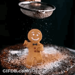 A Gingerbread Man Is Being Sprinkled With Powdered Sugar . GIF