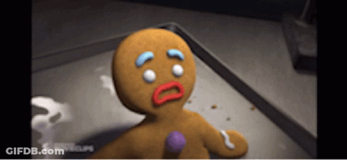 A Gingerbread Man Is Sitting On A Tray With A Sad Look On His Face GIF