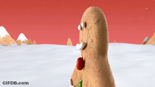 A Gingerbread Man Standing In The Snow With A Red Nose GIF