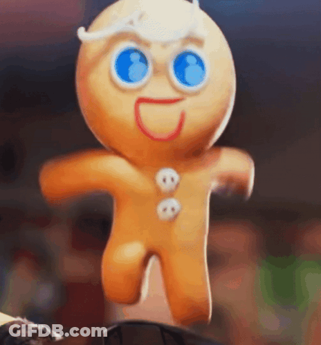 A Gingerbread Man With Blue Eyes Is Jumping In The Air While Standing On A Table . GIF