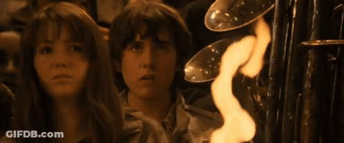 A Girl And A Boy Are Looking At A Fire GIF
