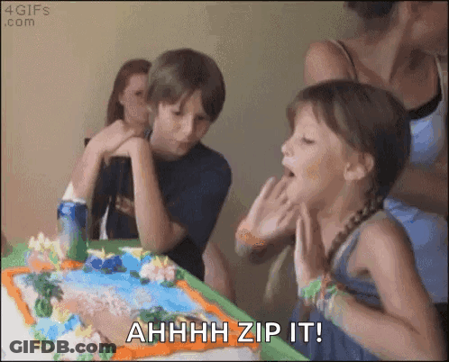 A Girl Blowing Out Candles On A Birthday Cake With The Words " Ahhhh Zip It " Written Below Her GIF