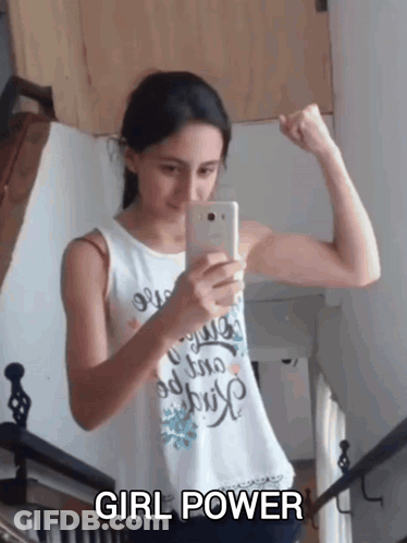A Girl Flexes Her Muscles While Taking A Picture Of Herself With The Words Girl Power Below Her GIF