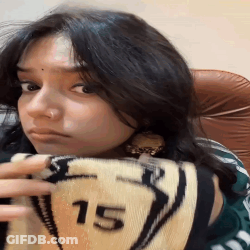 A Girl Holding A Blanket With The Number 15 On It GIF