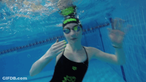 A Girl In A Black And Green Swimsuit Is Underwater GIF