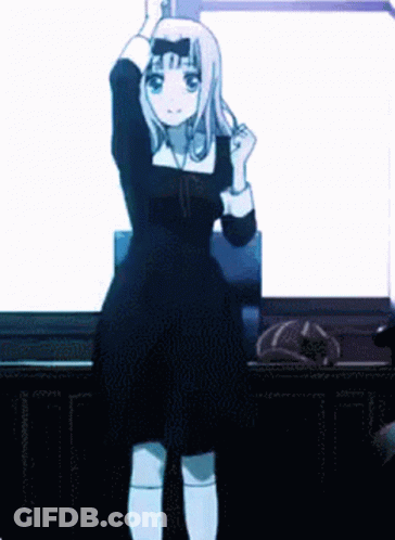 A Girl In A Black Dress Is Standing In Front Of A White Wall . GIF
