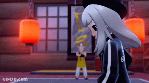 A Girl In A Black Jacket With The Letter G On The Back Stands In Front Of A Man In A Yellow Shirt GIF