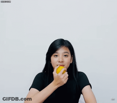 A Girl In A Black Shirt Is Holding A Yellow Object GIF