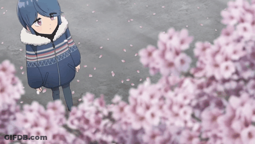 A Girl In A Blue And White Striped Jacket Stands In Front Of A Tree With Pink Flowers GIF