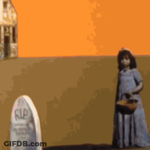 A Girl In A Blue Dress Is Standing In Front Of A Gravestone That Says Rip GIF