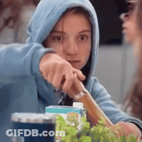 A Girl In A Blue Hoodie Is Holding A Knife . GIF