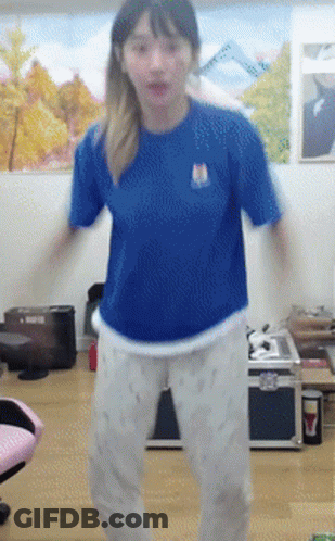 A Girl In A Blue Shirt And White Pants Is Dancing GIF