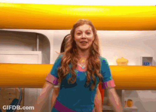 A Girl In A Blue Shirt Is Standing In Front Of A Yellow Wall With The Number 122 On It GIF