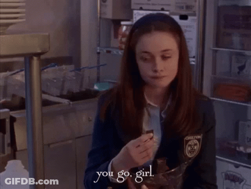 A Girl In A Chelton Uniform Is Holding A Bowl Of Chocolate GIF