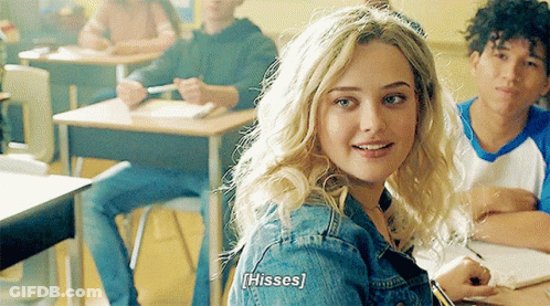 A Girl In A Classroom With The Word Hisses Written On Her Back GIF