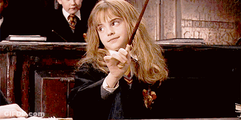 A Girl In A Harry Potter Uniform Is Holding A Wand In Her Hand GIF