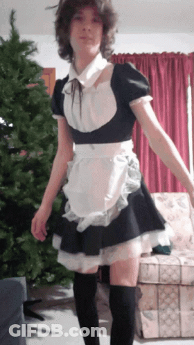 A Girl In A Maid Costume Is Standing In Front Of A Couch GIF