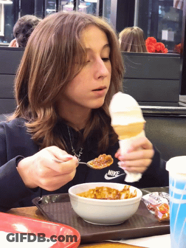 A Girl In A Nike Sweatshirt Is Eating A Bowl Of Food GIF