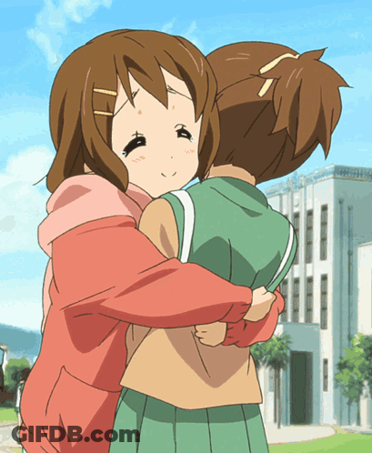 A Girl In A Pink Hoodie Is Hugging Another Girl In A Green Skirt GIF