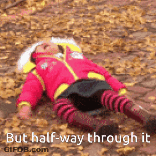 A Girl In A Pink Jacket Is Laying On The Ground With The Words But Half-Way Through It Below Her GIF