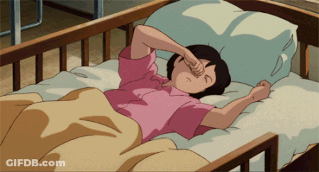 A Girl In A Pink Shirt Is Laying In A Bed And Rubbing Her Eyes GIF