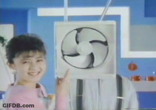 A Girl In A Pink Shirt Is Smiling And Holding A Fan GIF