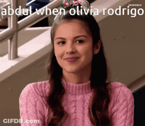 A Girl In A Pink Sweater Is Smiling With The Caption Abdul When Olivia Rodrigo Above Her GIF