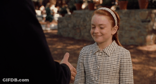 A Girl In A Plaid Shirt Smiles While Giving A Thumbs Up GIF