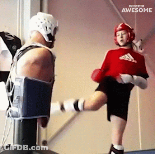 A Girl In A Red Adidas Shirt Kicking A Man In A Helmet GIF