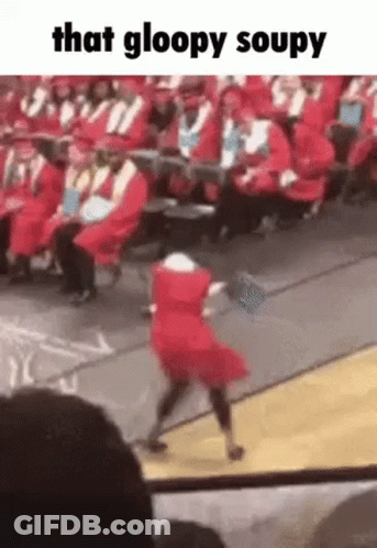A Girl In A Red Dress Is Dancing On A Stage At A Graduation Ceremony . GIF