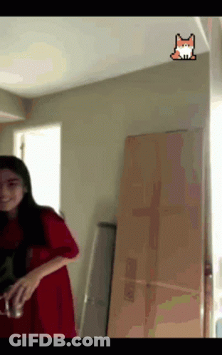 A Girl In A Red Dress Is Standing In A Room With A Fox Sticker On The Ceiling GIF