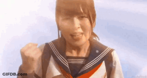 A Girl In A Sailor Uniform Is Making A Fist In The Air . GIF