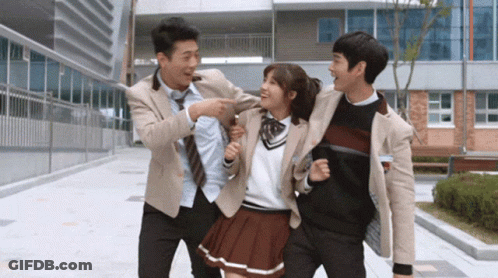 A Girl In A School Uniform Is Being Held By Two Boys GIF