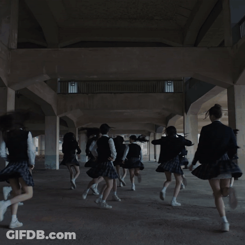A Girl In A School Uniform Is Dancing With Her Hands In The Air GIF