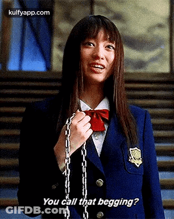 A Girl In A School Uniform Is Holding A Chain Around Her Neck . GIF