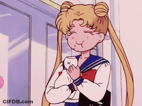 A Girl In A School Uniform Is Holding A Tooth In Her Hands . GIF