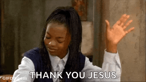 A Girl In A School Uniform Is Sitting At A Table With Her Hands In The Air And Saying `` Thank You Jesus '' . GIF