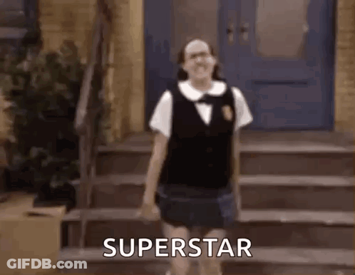A Girl In A School Uniform Is Standing On A Set Of Stairs And Says Superstar . GIF
