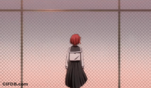 A Girl In A School Uniform Stands Behind A Chain Link Fence GIF