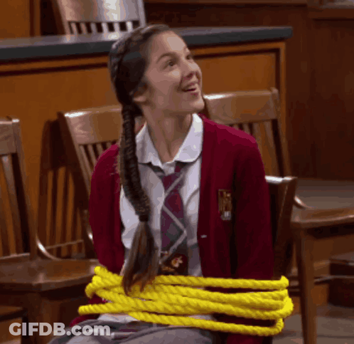 A Girl In A School Uniform Tied Up With Yellow Rope GIF