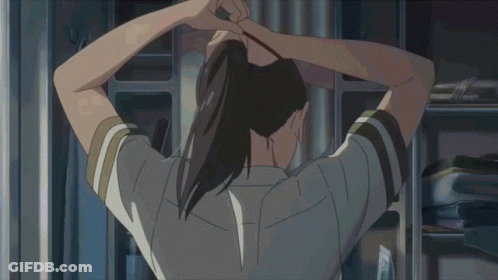 A Girl In A School Uniform With A Red Bow On Her Shirt Is Tying Her Hair Up GIF